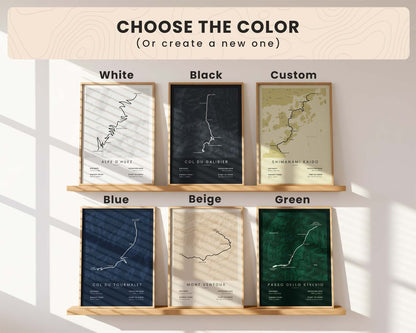 Set of framed custom cycling maps with color options displayed on a wooden shelf.