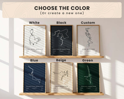 Collection of framed marathon route maps with color options displayed on a shelf.