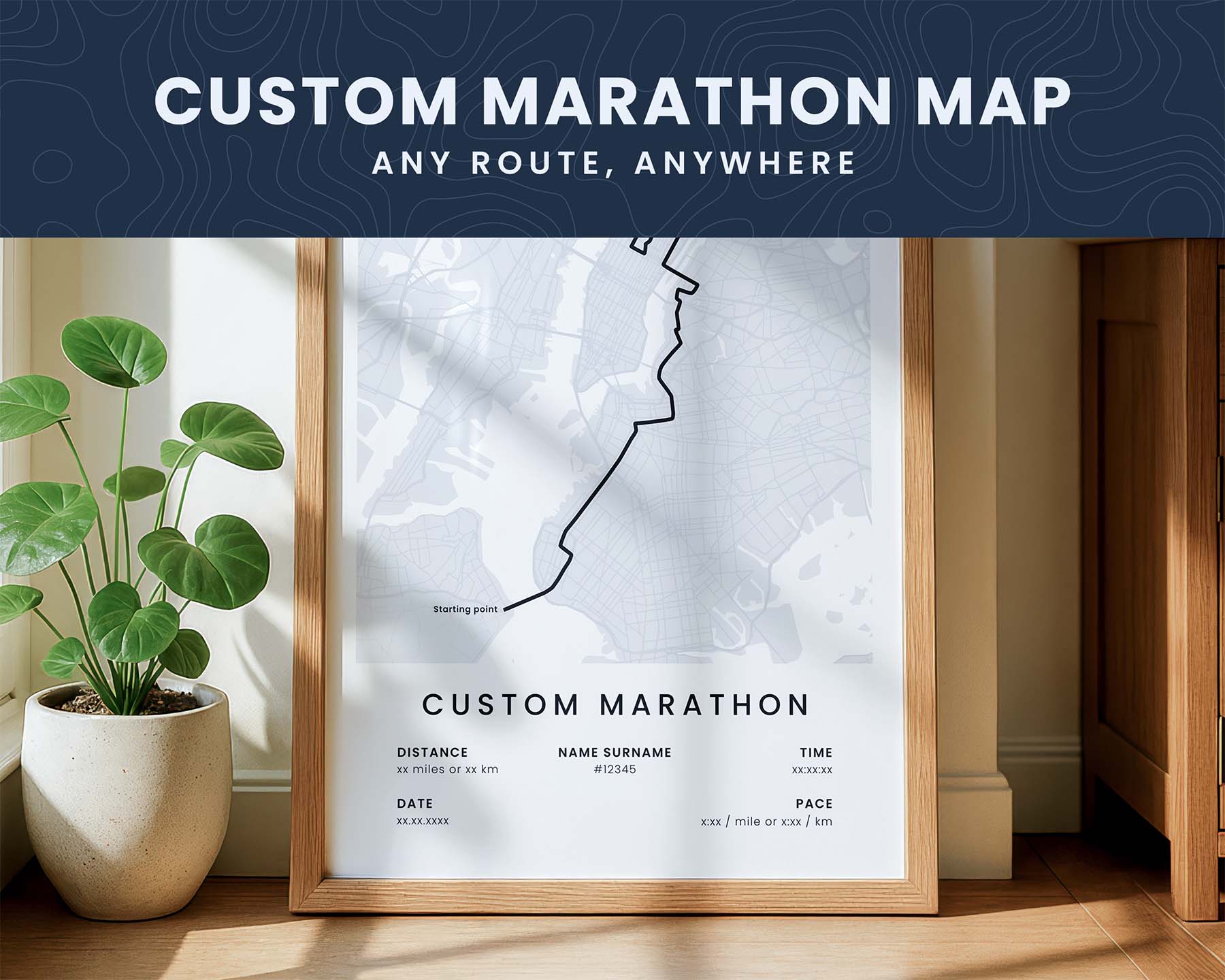 Framed custom marathon map on a wall with a plant and wooden cabinet in the background.