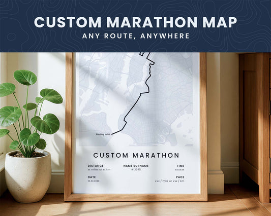 Framed custom marathon map on a wall with a plant and wooden cabinet in the background.